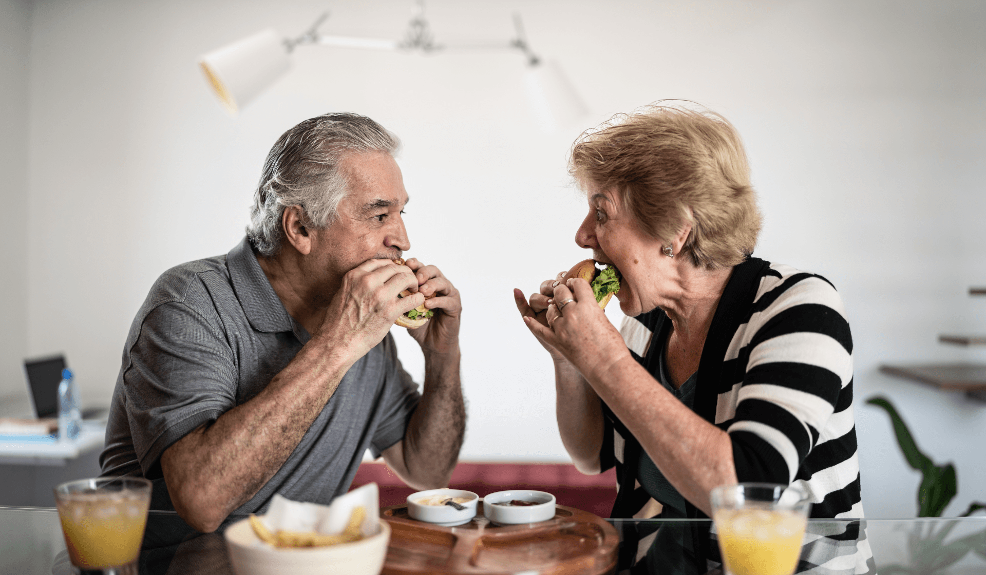 senior citizens eating burgers together.